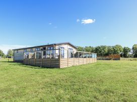 A building with decking and grass area at Angel Lodge - No 27 in Fornham St Genevieve near Bury St Edmunds
