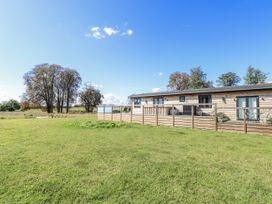 An outdoor area with a building and a fence at Angel Lodge - No 27 Fornham St Genevieve near Bury St Edmunds