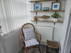 A snug area with a chair and shelf displayed with decorations at Seahorses