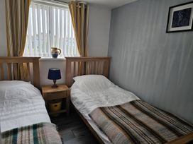 A bedroom with two beds and a window at Seahorses