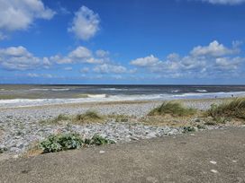 A beach scene with pebbles and waves at Seahorses in Kinmel Bay