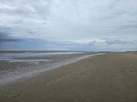 A beach with sand and water at Seahorses in Kinmel Bay