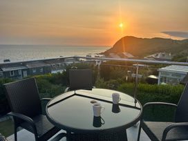 A table and chairs with mugs overlooking the sea at Combe View in Ilfracombe