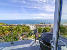 A balcony with a table and chairs overlooking the sea at Combe View, Ilfracombe