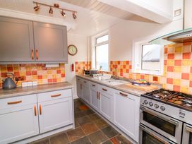 A kitchen with cabinets, oven, and sink at Combe View in Ilfracombe