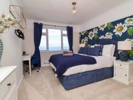 A bedroom with a bed and desk at Combe View in Ilfracombe