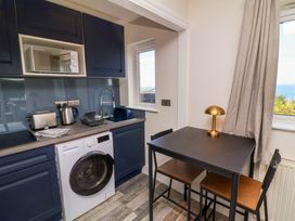 A kitchen with appliances and a dining table at Combe View Ilfracombe