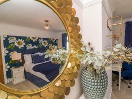 A bedroom featuring a bed with floral wallpaper at Combe View Ilfracombe