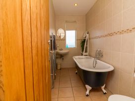 A bathroom with a bathtub, sink, and towel rack at Combe View in Ilfracombe