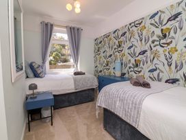 A bedroom with two beds and a window at Combe View in Ilfracombe