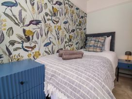 A bedroom with a single bed and decorative wallpaper at Combe View in Ilfracombe
