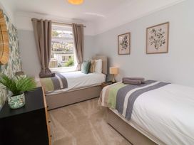 A bedroom with two beds and decorative wall art at Combe View in Ilfracombe