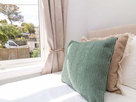 A bedroom with a window and cushions at Combe View Ilfracombe