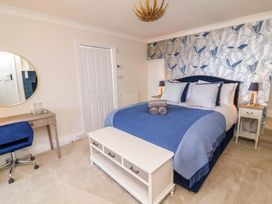 A bedroom with a bed, table, and chair at Combe View in Ilfracombe