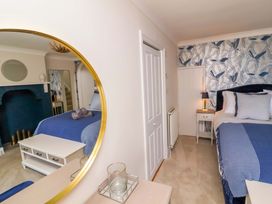 A bedroom with a bed, table, and lamp at Combe View Ilfracombe