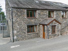 An outdoor view of a stone building with windows and stairs at Rockside At Pound Farm Crook near Kendal