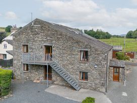 A stone building with a staircase and windows at Rockside At Pound Farm Crook near Kendal