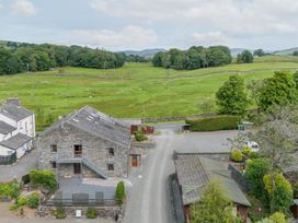 An outdoor view of a stone building and surrounding landscape at Bank Barn At Pound Farm Crook near Kendal