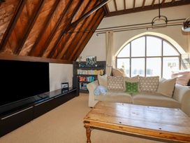 A living room with a couch and bookshelf at The Old Village Chapel in Crantock