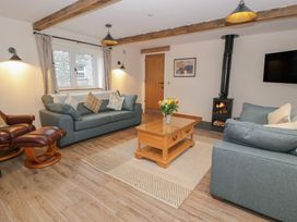 A living room with a sofa, armchair, and coffee table at Y Stabl in Cerrigydrudion