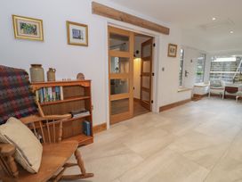 A snug with a rocking chair and bookshelves at Y Stabl in Cerrigydrudion