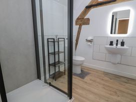 A bathroom with a shower, sink, and toilet at Y Stabl in Cerrigydrudion
