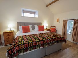 A bedroom with a bed and bedside tables at Y Stabl in Cerrigydrudion