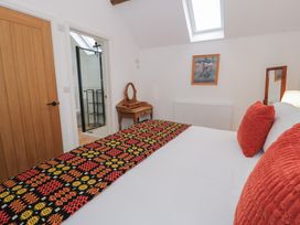 A bedroom with a bed and table at Y Stabl in Cerrigydrudion
