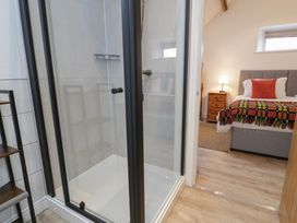A bathroom with a shower and a bedroom view at Y Stabl in Cerrigydrudion