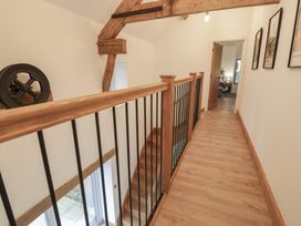 A hallway with wooden railing and staircase at Y Stabl in Cerrigydrudion