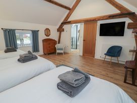 A bedroom with two beds and a chest of drawers at Y Stabl in Cerrigydrudion