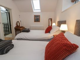 A bedroom with two beds and a painting at Y Stabl in Cerrigydrudion