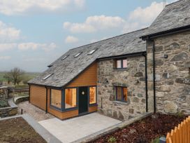 An exterior view of a house with a stone and wooden facade at Y Stabl in Cerrigydrudion