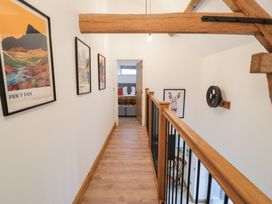 A hallway with wooden beam and wall art at Y Stabl in Cerrigydrudion
