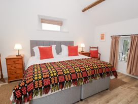 A bedroom with a bed and nightstands at Y Stabl in Cerrigydrudion