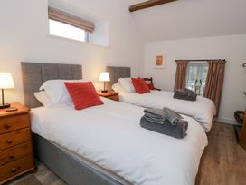 A bedroom with two single beds and nightstands at Y Stabl in Cerrigydrudion