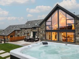 An outdoor area with a hot tub and furniture at Y Côr in Cerrigydrudion