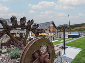 An outdoor area with a rusty wheel and hot tub at Y Côr in Cerrigydrudion