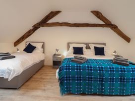 A bedroom with two beds and a bedside table at Y Côr in Cerrigydrudion