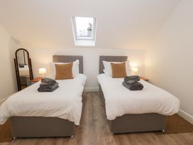 A bedroom with two single beds and a mirror at Y Côr in Cerrigydrudion