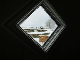 A view of snow-covered landscape through a window at Y Côr in Cerrigydrudion