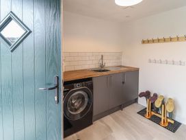 A utility room with a washer and sink at Y Côr in Cerrigydrudion