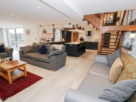 A living room with a sofa and kitchen area at Y Côr in Cerrigydrudion