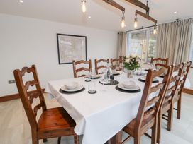 A dining room with a large table set for dinner at Y Côr in Cerrigydrudion