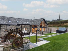 An outdoor space with a hot tub and garden features at Y Côr in Cerrigydrudion