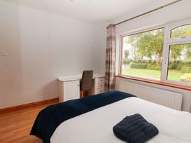 A bedroom featuring a bed, desk, chair, and window at Fort Lodge