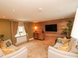 A living room with a sofa and television at Clematis Cottage in Whitby