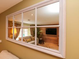 A living room with a mirror reflecting furniture at Clematis Cottage in Whitby