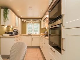A kitchen with cabinets and appliances at Clematis Cottage in Whitby