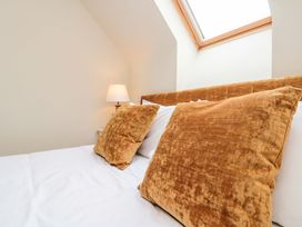 A bed with pillows and a lamp in the bedroom at Clematis Cottage in Whitby